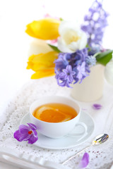 Obraz na płótnie Canvas cup of tea with lemon and spring flowers, soft focus