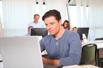 Fototapeta na wymiar Portrait of office worker in front of laptop computer