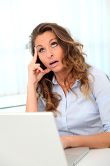 Office worker with desperate look in front of laptop