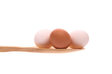 Eggs  on a wooden spoon isolated on a white background