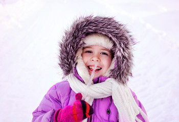 Smiling girl dressed warmly holding an icicle