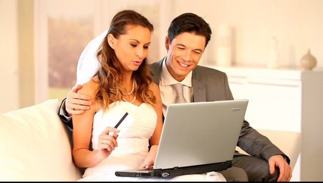 Bride and groom doing shopping on inernet at home