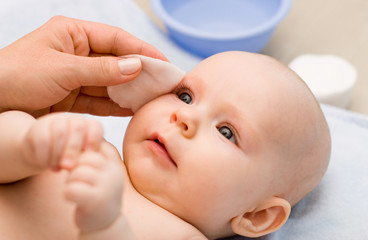 cleaning baby 's eye with cotton pad