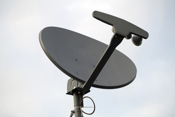 TV Dish backlit against light blue sky