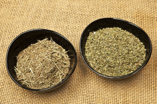 Black bowls with rosemary and marjoram spices.