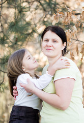 Fototapeta premium Mother and daughter have fun - beautiful forest in background