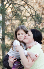 Fototapeta premium Mother and daughter have fun - beautiful forest in background