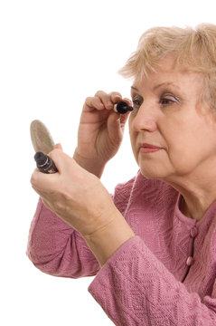The elderly woman does a make-up