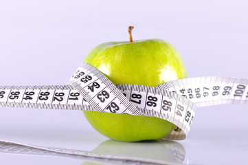 green apple surrounded by white tapeline on white