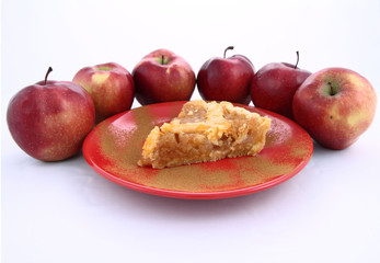 Apple Pie-slice on a plate with cinnamon and some red apples