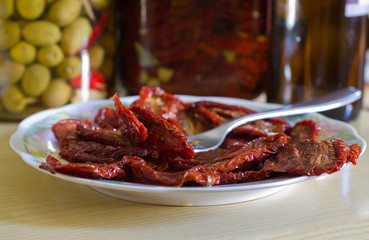 dish of dried tomatoes in oil with metal fork