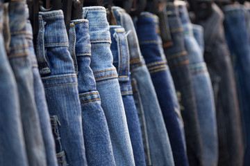 Row of hanged blue jeans in a shop