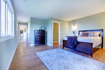 Fresh green bedroom with modern brown bed