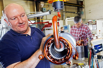 skilled industrial workers mounting electric motors 01