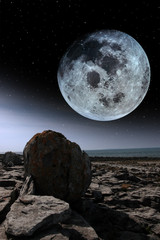 full moon and boulders in rocky burren landscape