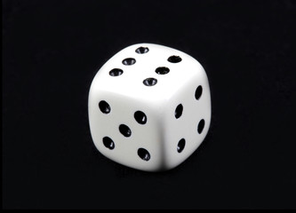 White dice cube toy on black background