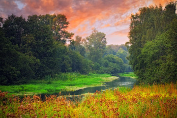 Landscape with small forest river on sunset