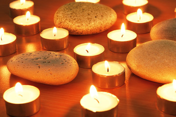 Burning candles and pebbles for aromatherapy session