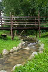 wooden bridge over small brook in a forest