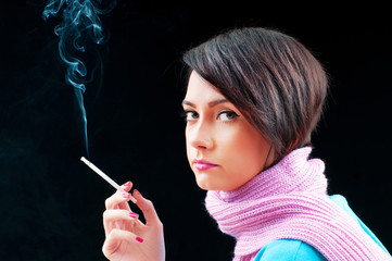 Obraz premium Young girl smoking on black