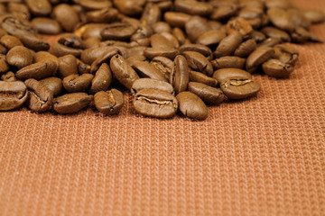 coffee beans scattered on a brown braided material