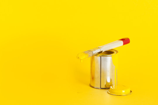 gelbe farbdose mit pinsel auf gelbem hintergrund