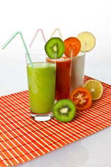 Trinkjoghurt Kiwi, Zitrone und Tomatensaft im Glas mit Früchten