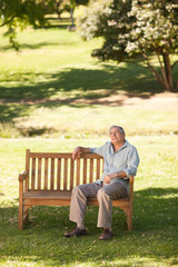 Fototapeta premium Elderly man sitting on a bench