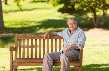 Fototapeta premium Elderly man sitting on a bench