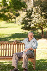 Fototapeta premium Elderly man sitting on a bench