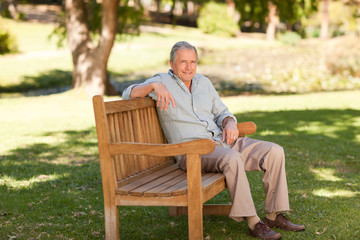 Naklejka na ściany i meble Senior man sitting on a bench
