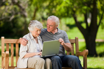 Elderly couple looking at their laptop