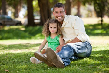 Fototapeta premium Father with his daughter sitting on the garden
