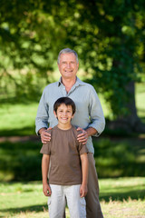 Grandather and his grandson looking at the camera in the park