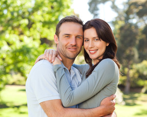 Fototapeta premium Radiant couple hugging in the park