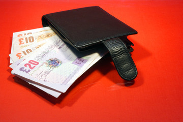 Wallet with banknotes on the red glass table