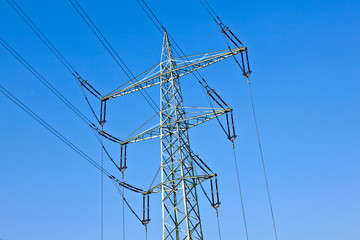 .Electricity tower with power lines against a  blue sky .