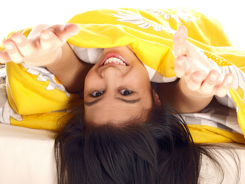 Smiling Teenage Girl Waking Up Stretching In Bed