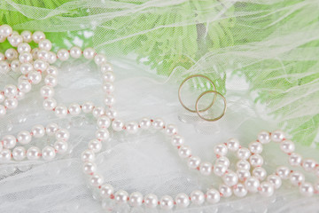 necklace of pearls, wedding rings and bouquet of chrysanthemums