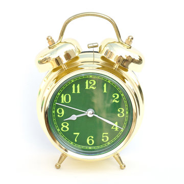 Gold old style alarm clock on white background