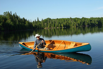 Canoeist paddling solo on a lake in northern Ontario, Canada