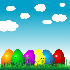 Easter eggs on the grass over cloudy blue sky