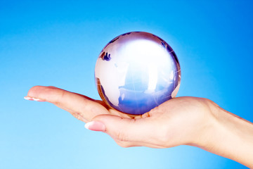 Crystal ball on hand. blue background
