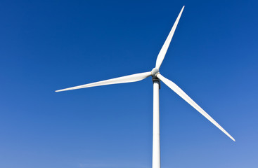 White wind turbine generating electricity on blue sky