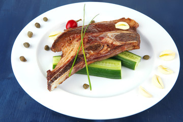 red beef meat steak on white plate with capers