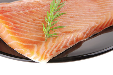 fresh raw salmon fillet on black with rosemary