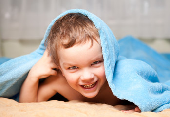Little boy under a blue blanket