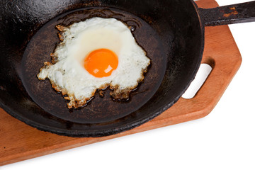 Fried eggs on a frying pan on a board