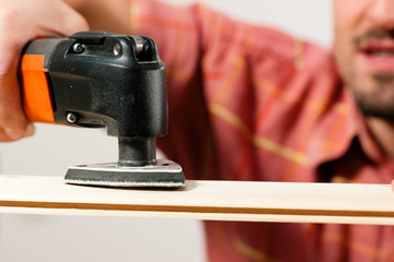 Mann schleift ein Brett