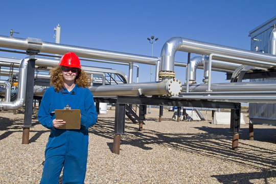 Female gas field operator inspects compressor site